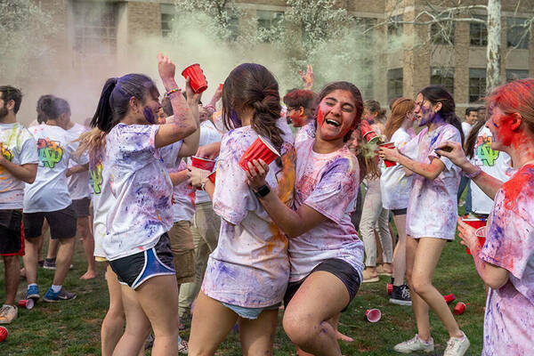 Students celebrate the Holi festival as they toss vibrant colored chalk into the air on North Quad.